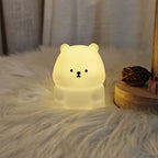 Luz Noturna Urso Filhote com Iluminação LED Suave e Não Ofuscante. Feita de Material PVC, Compacta e Portátil, Alimentada por Pilhas Botão. Ideal para Uso em Escrivaninhas ou Mesas de Cabeceira