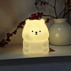 Luz Noturna Urso Filhote com Iluminação LED Suave e Não Ofuscante. Feita de Material PVC, Compacta e Portátil, Alimentada por Pilhas Botão. Ideal para Uso em Escrivaninhas ou Mesas de Cabeceira