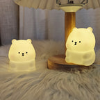 Luz Noturna Urso Filhote com Iluminação LED Suave e Não Ofuscante. Feita de Material PVC, Compacta e Portátil, Alimentada por Pilhas Botão. Ideal para Uso em Escrivaninhas ou Mesas de Cabeceira